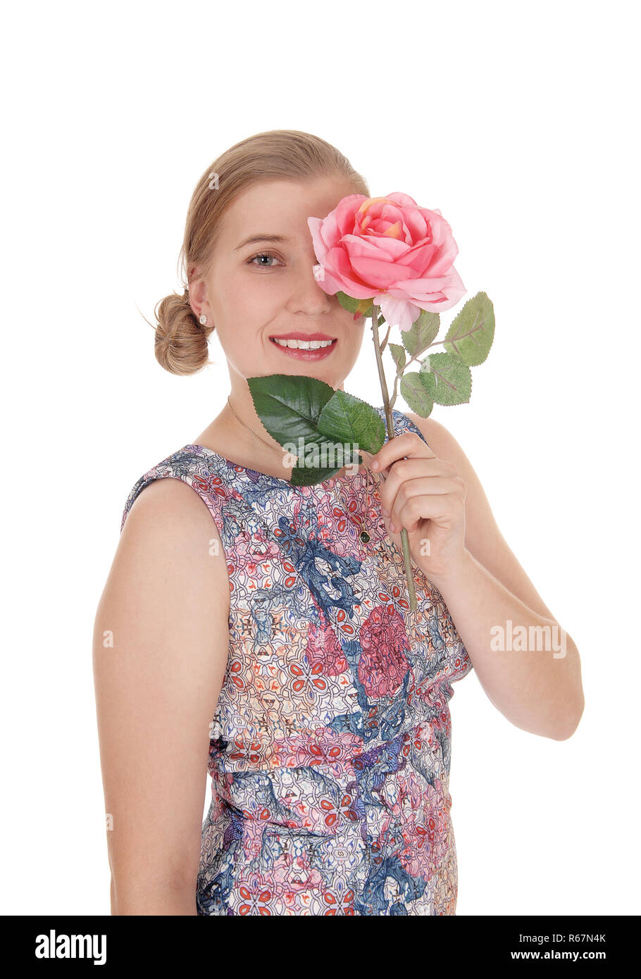 Woman standing in dress with rose on her face Stock Photo