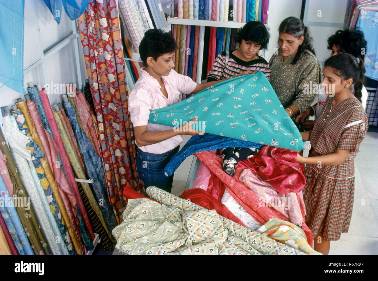 saleswoman showing material to customers, shop, india Stock Photo