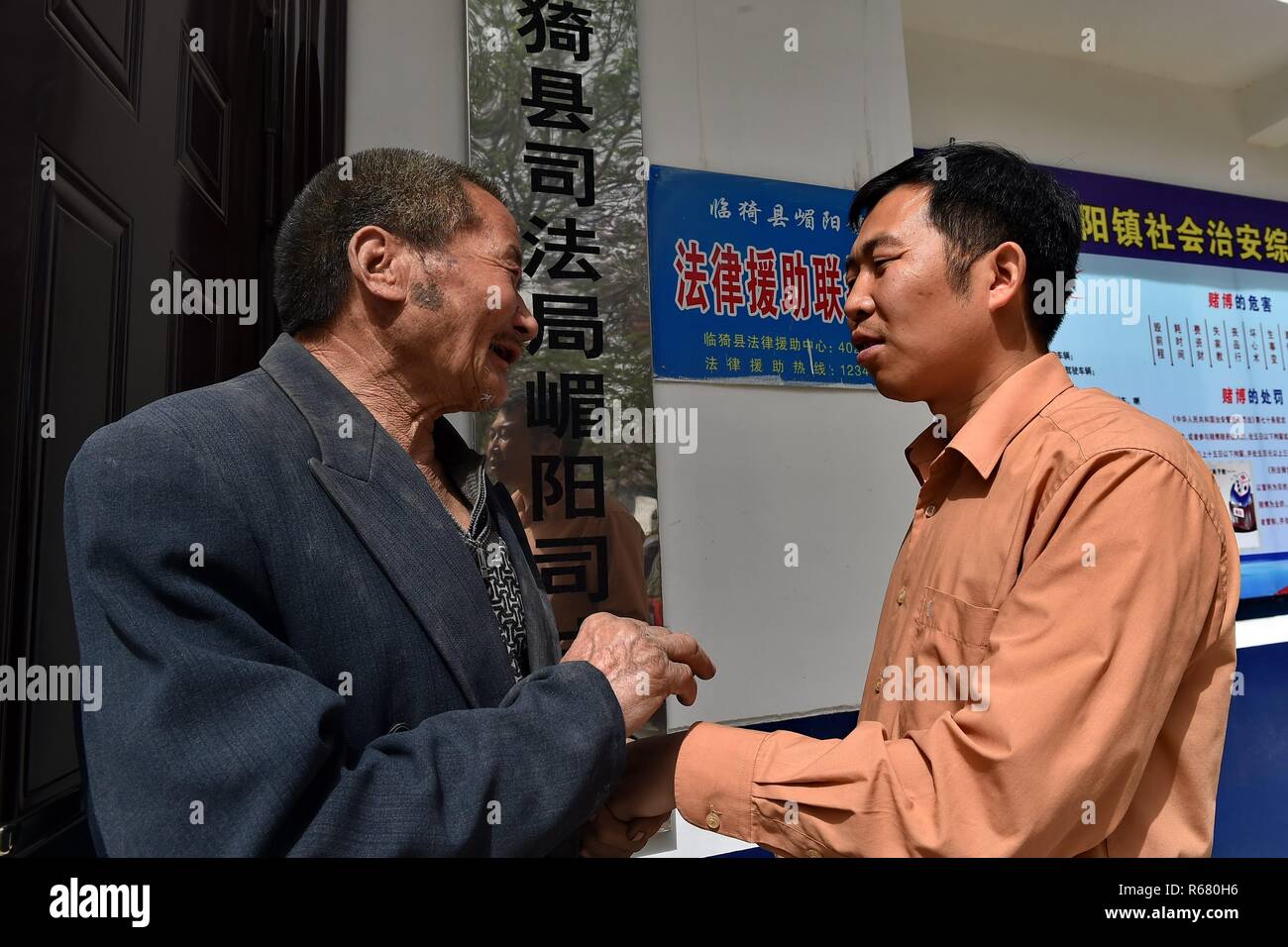 (181204) -- BEIJING, Dec. 4, 2018 (Xinhua) -- Villager Wen Xinmao shakes hands with Chen Jian (R), director of the judicial office of Meiyang Town, to extend his gratitude after a civil mediation in Meiyang Village, Linyi County of north China's Shanxi Province, April 18, 2017. Legal aid institutions across China have handled about 6.34 million cases during the past five years, helping 6.96 million people, the Ministry of Justice said Thursday. Over the past five years, legal aid institutions at all levels have helped 2.47 million migrant workers, 328,000 people with disabilities, 585, 0 Stock Photo