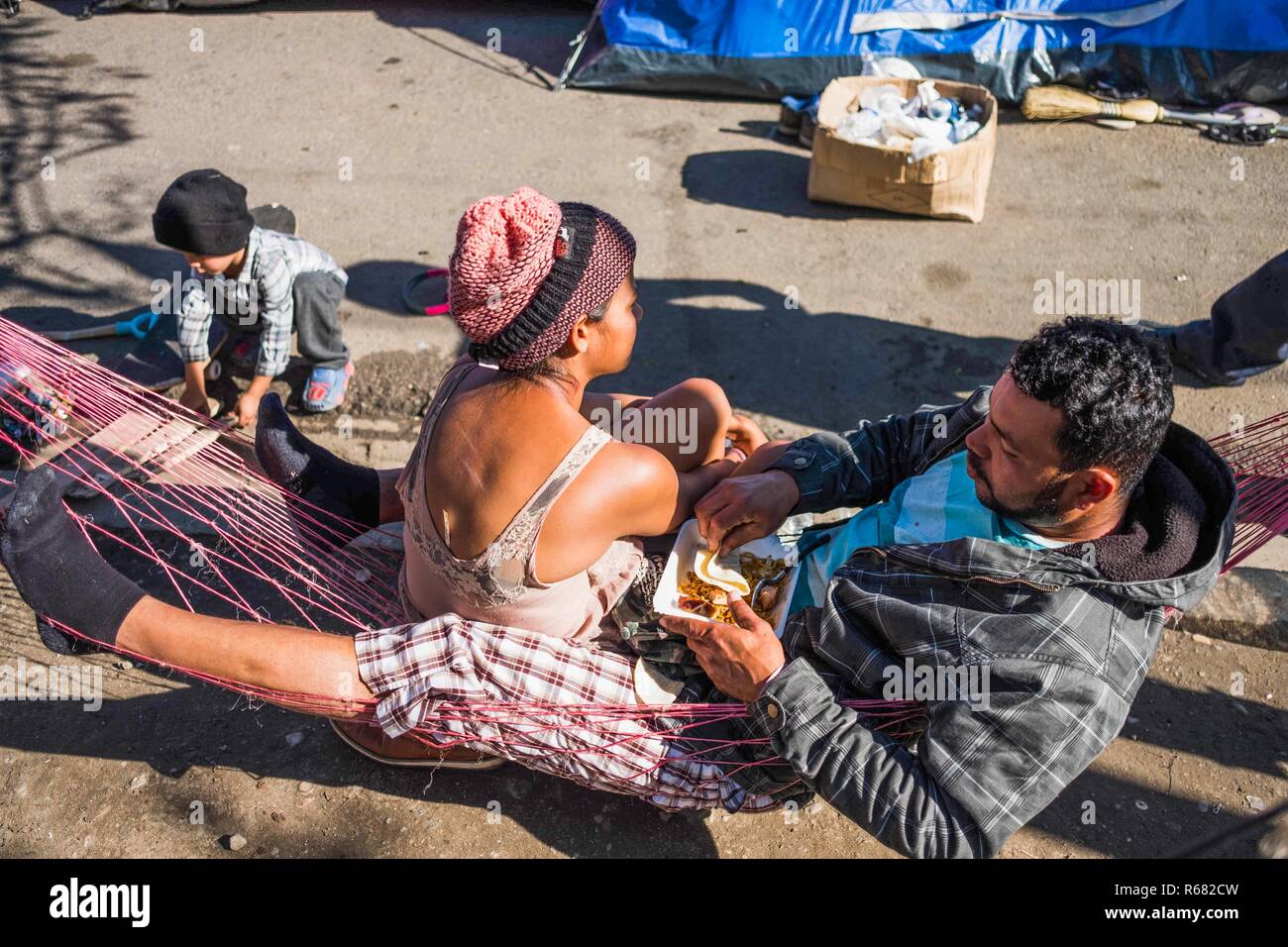 Members of the migrant caravan are seen resting in makeshift conditions as they await for asylum in the United States. Around 6,000 migrants are staying in a new temporary shelter where they wait for asylum in the United States. Stock Photo