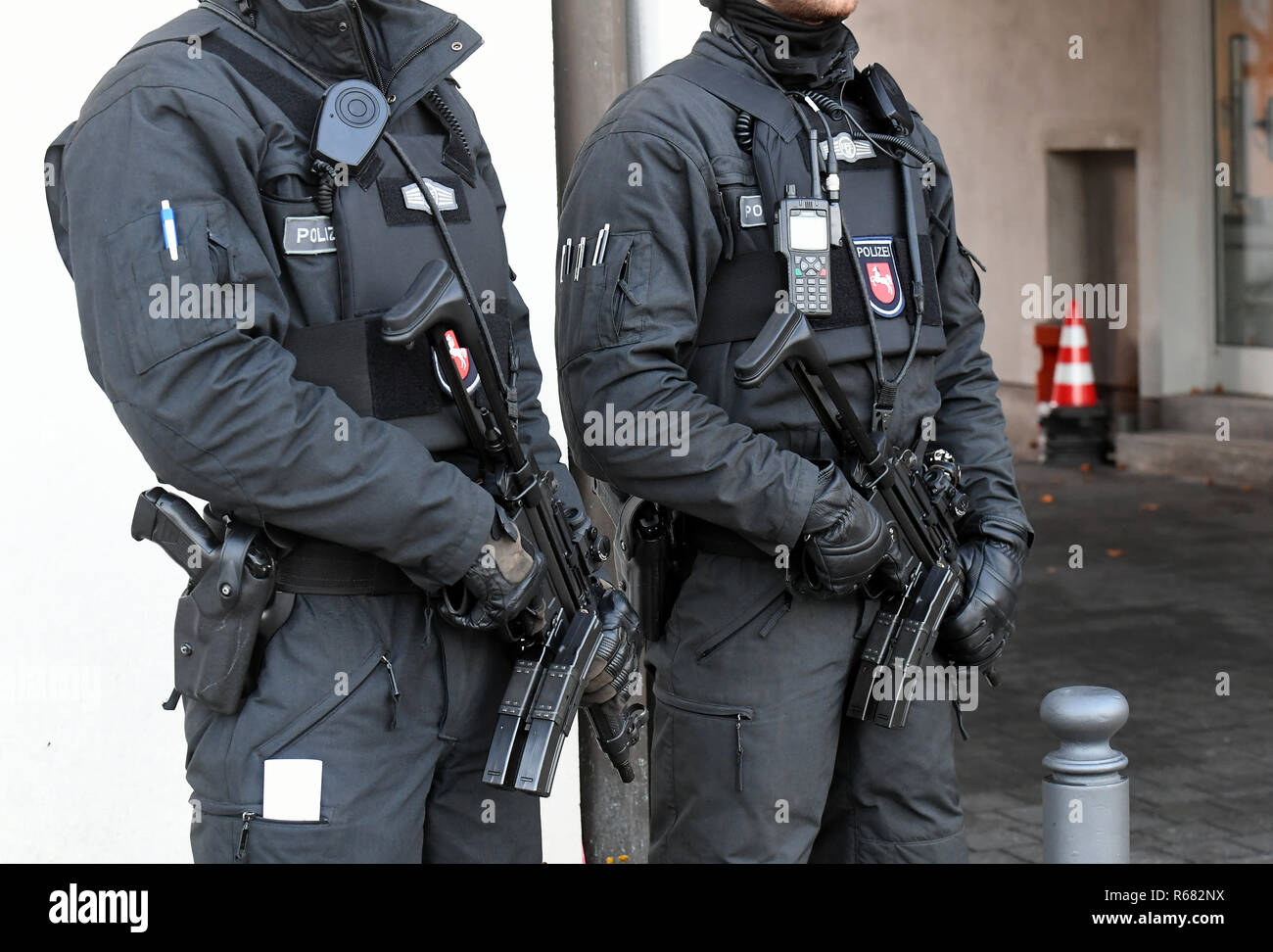Celle, Germany. 04th Dec, 2018. Armed police officers secure an entrance to the Higher Regional Court. Abu Walaa, presumed leader of the terrorist militia Islamic State (IS) in Germany, and four other presumed top Islamists on trial are said to have recruited volunteers for the IS. From this Tuesday (04.12.2018) on a new witness will be heard. He is one of the convicted juvenile assassins of the Sikh Temple in Essen in 2016 with three injured. Credit: Holger Hollemann/dpa/Alamy Live News Stock Photo