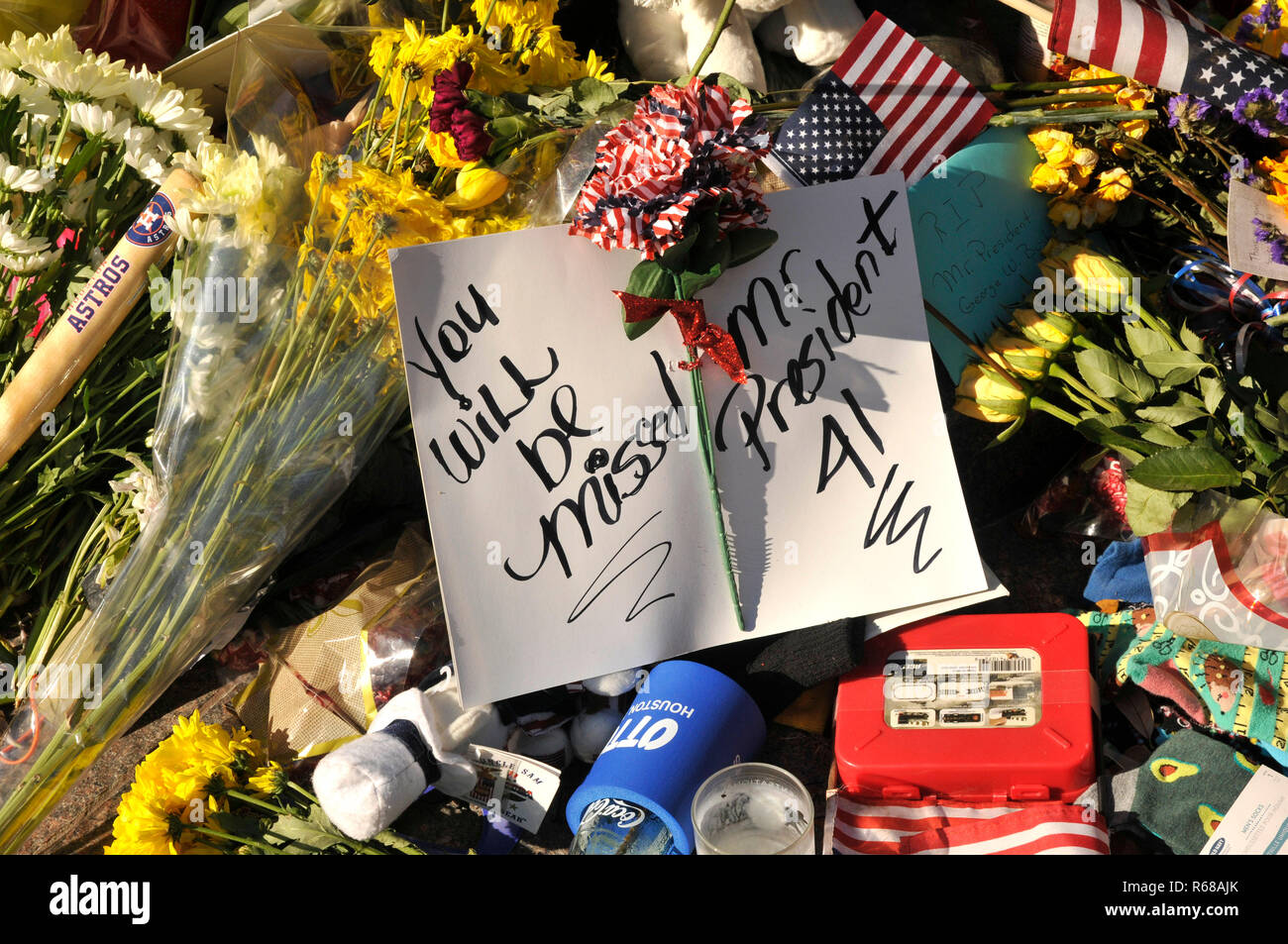 Houston, Texas, USA. 4th Dec, 2018. Houstonians place flowers and gifts at President George H.W. Bush Statue in Downtown Houston. Credit: George Wong/ZUMA Wire/Alamy Live News Stock Photo