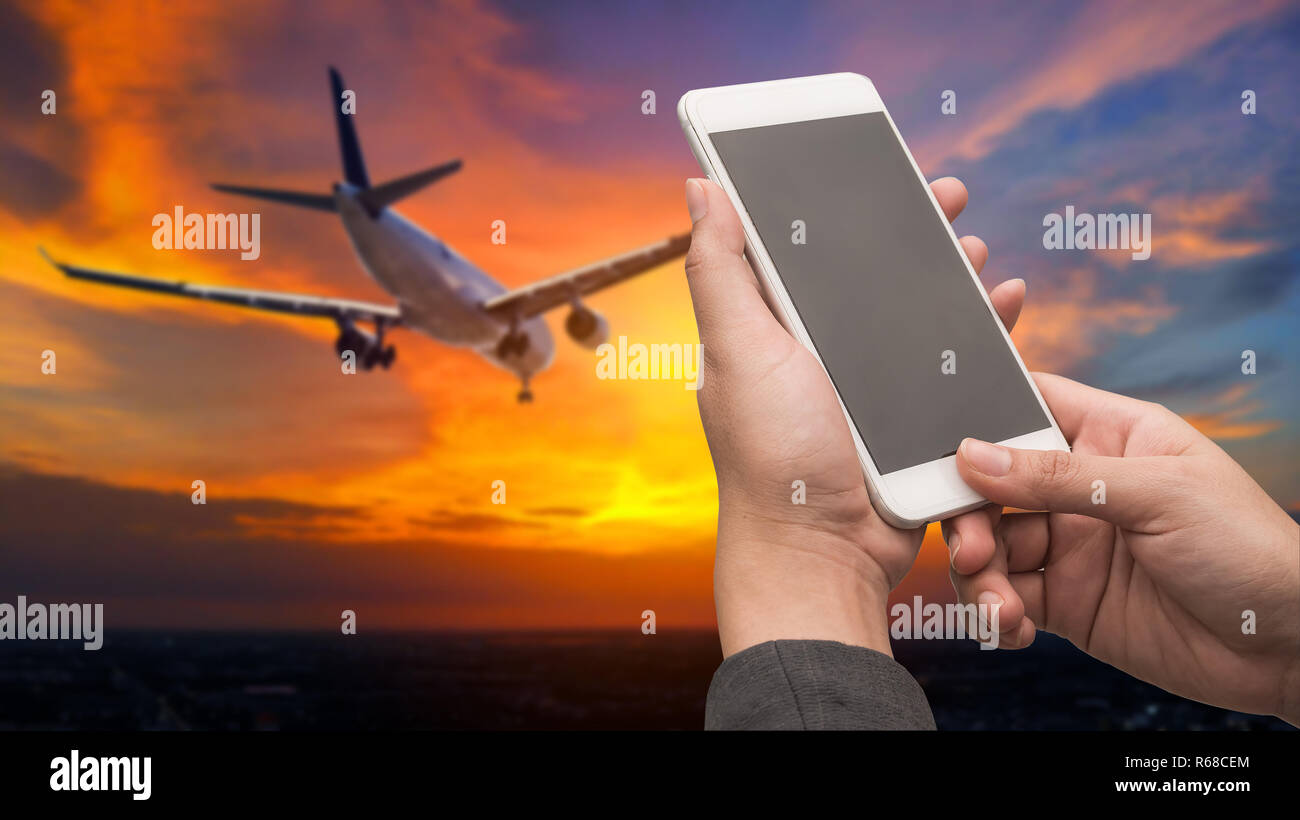 Business woman hand holding smartphone with airline background concept. Stock Photo