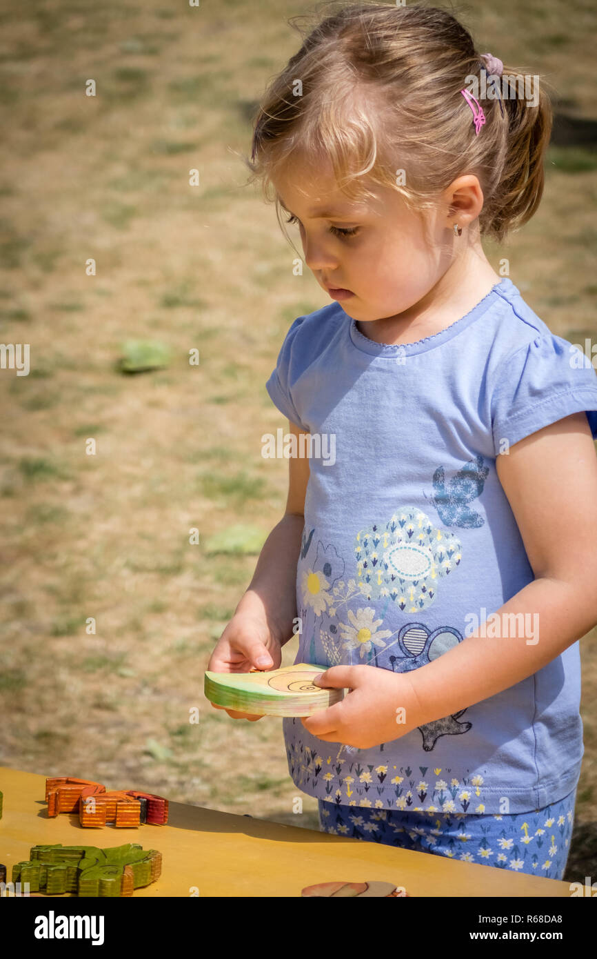 Little girl playing with the wooden puzzle Stock Photo - Alamy