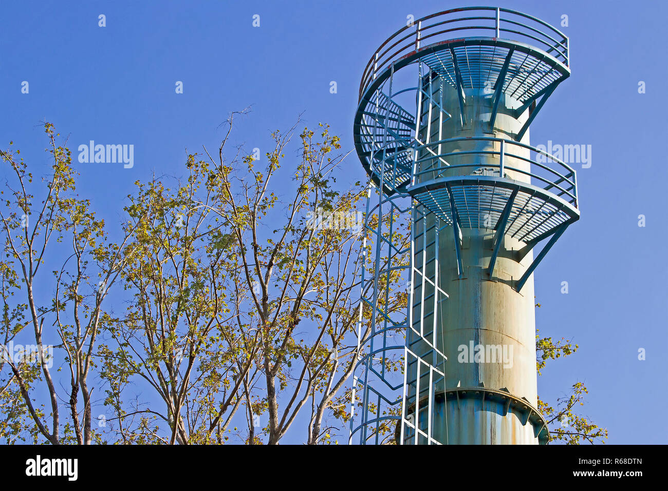 Water tower and blue sky  is near tree Stock Photo