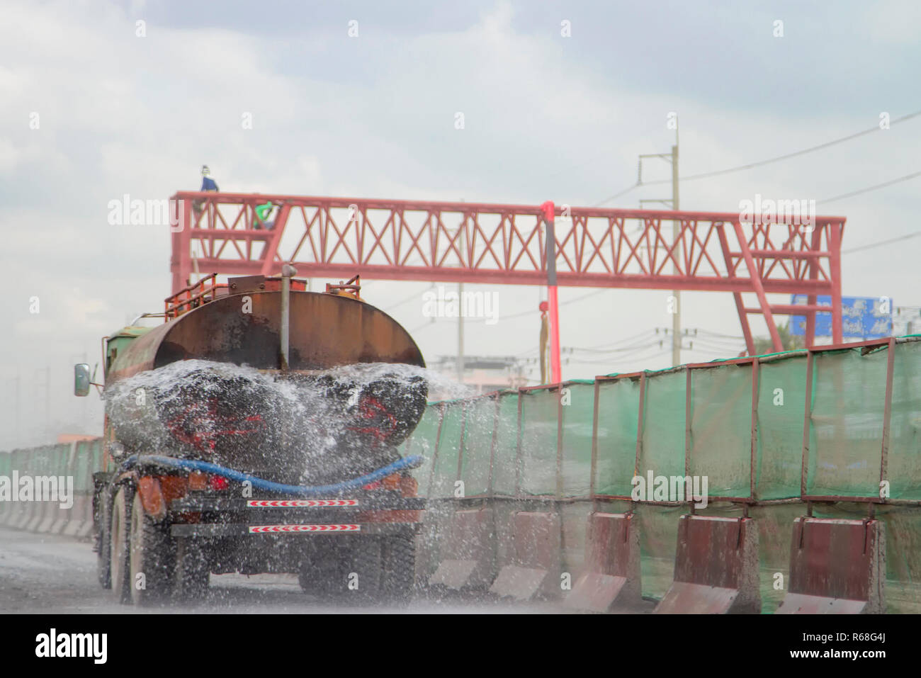 Car water tanker spray on the road Stock Photo