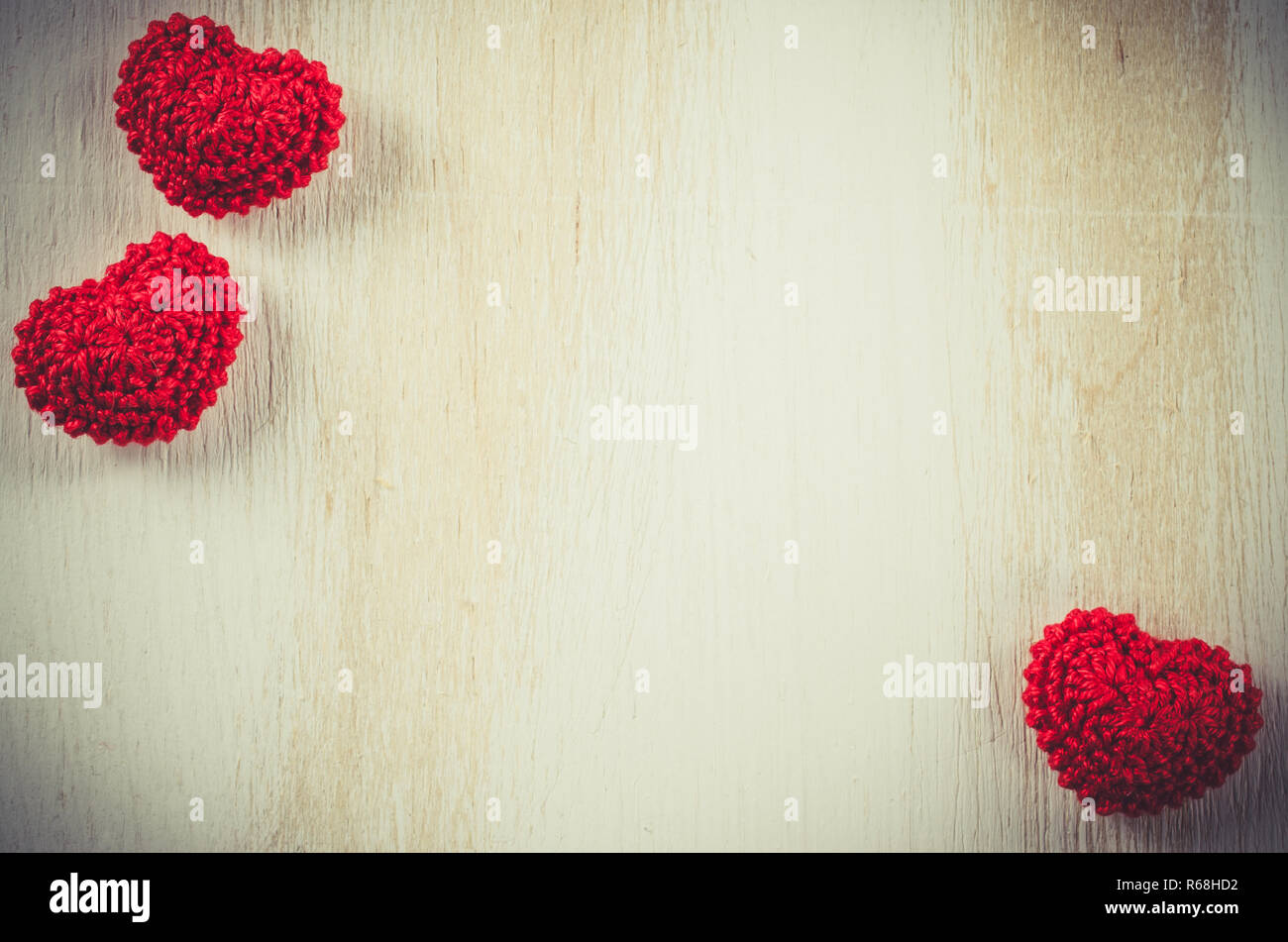 Knitted red hearts on a vintage wooden background Stock Photo - Alamy