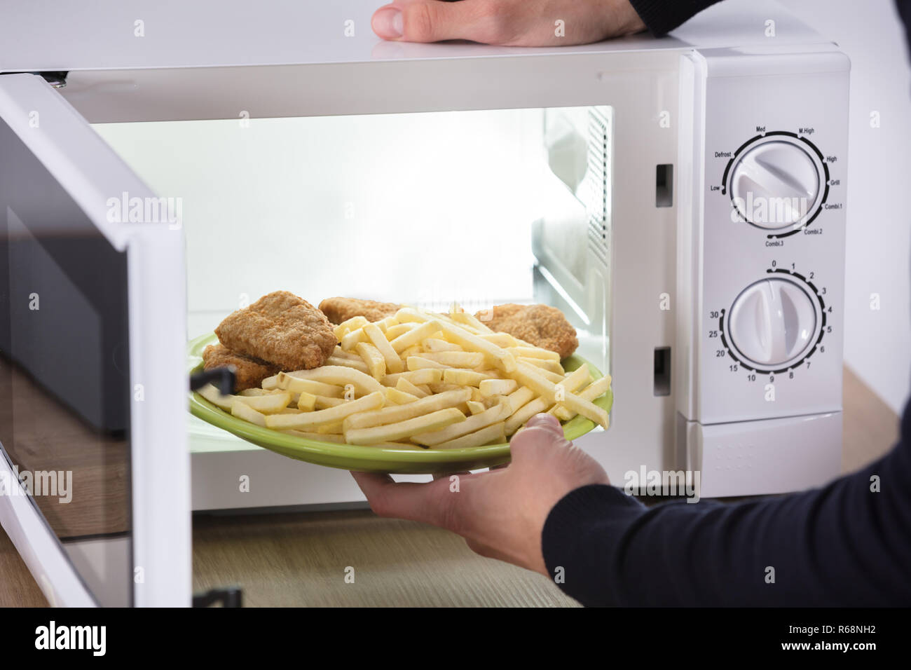 Person Putting Fried Food Inside Microwave Oven Stock Photo Alamy