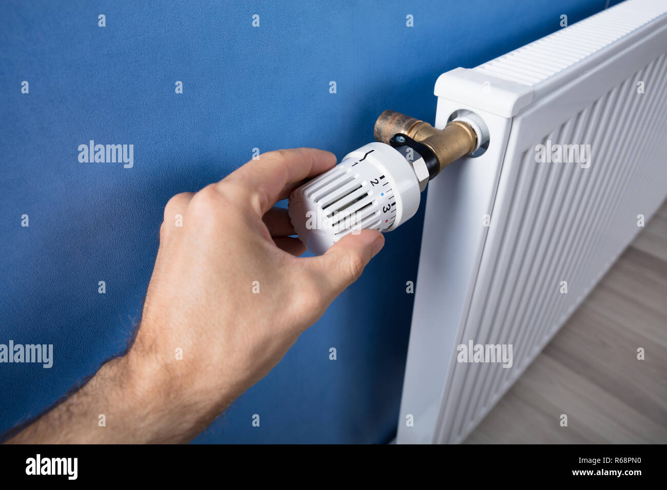 Hand Adjusting Temperature On Thermostat Stock Photo