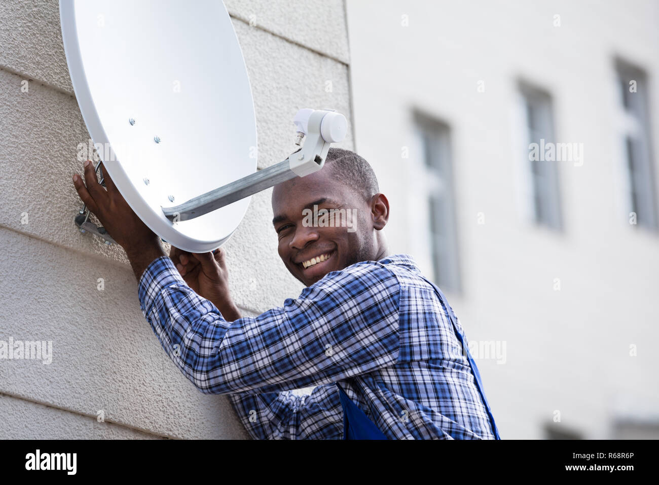 Man In Uniform Fitting TV Satellite Dish Stock Photo Alamy