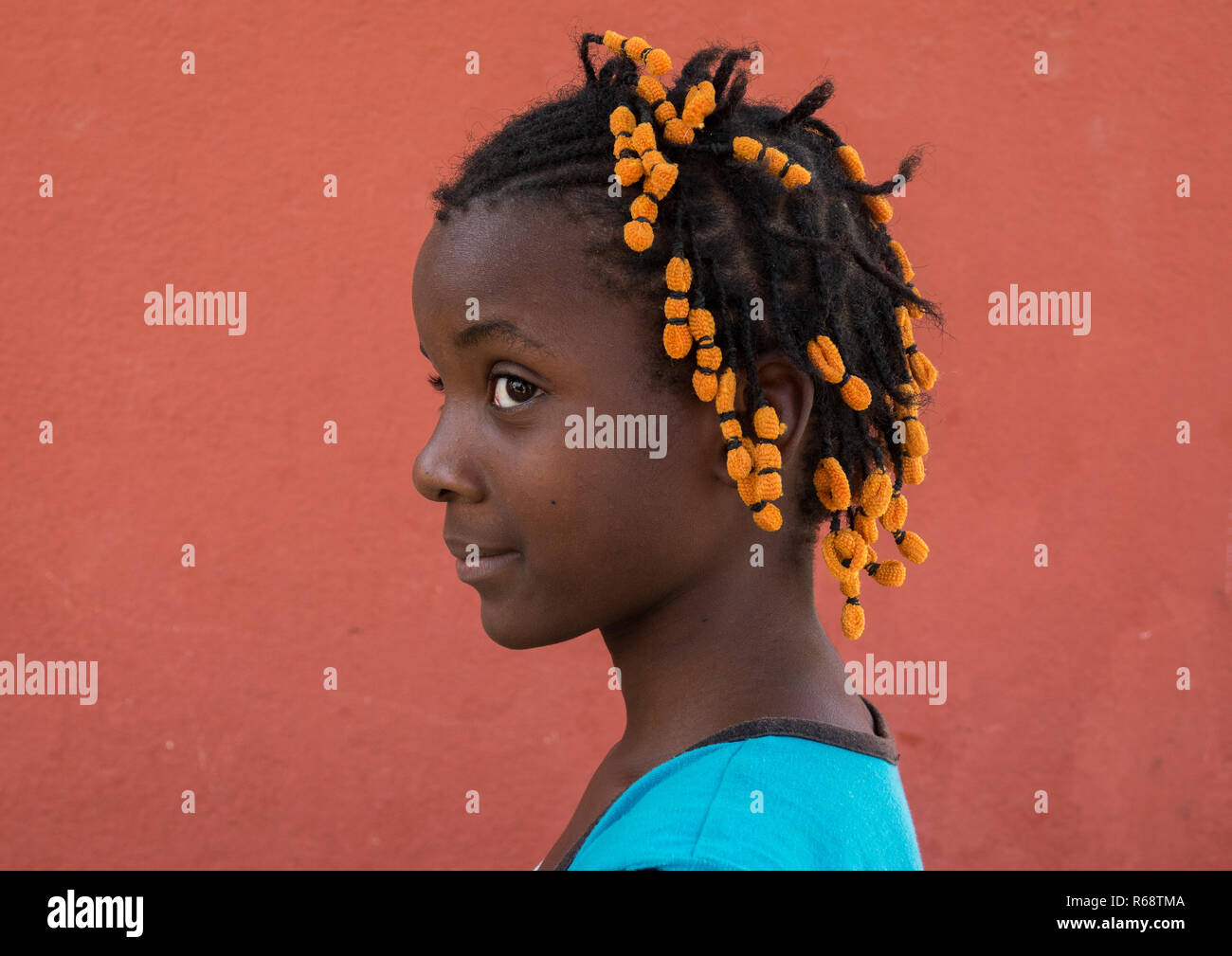 Portrait of a Angolan girl with the typical hairstyle made of braids with colorful scrunchies, Benguela Province, Catumbela, Angola Stock Photo