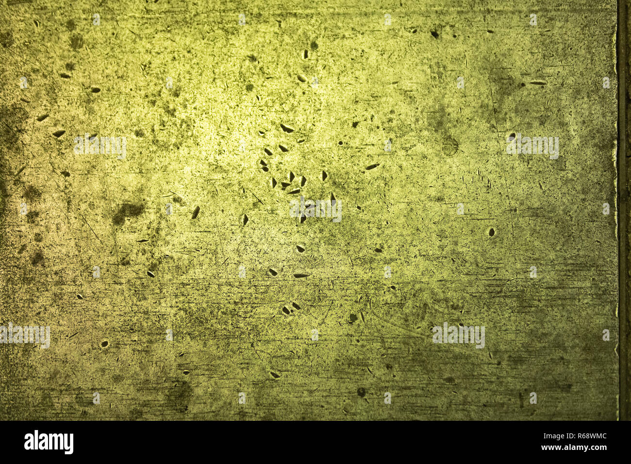 Scratches in a solid metal surface in green light. Stock Photo
