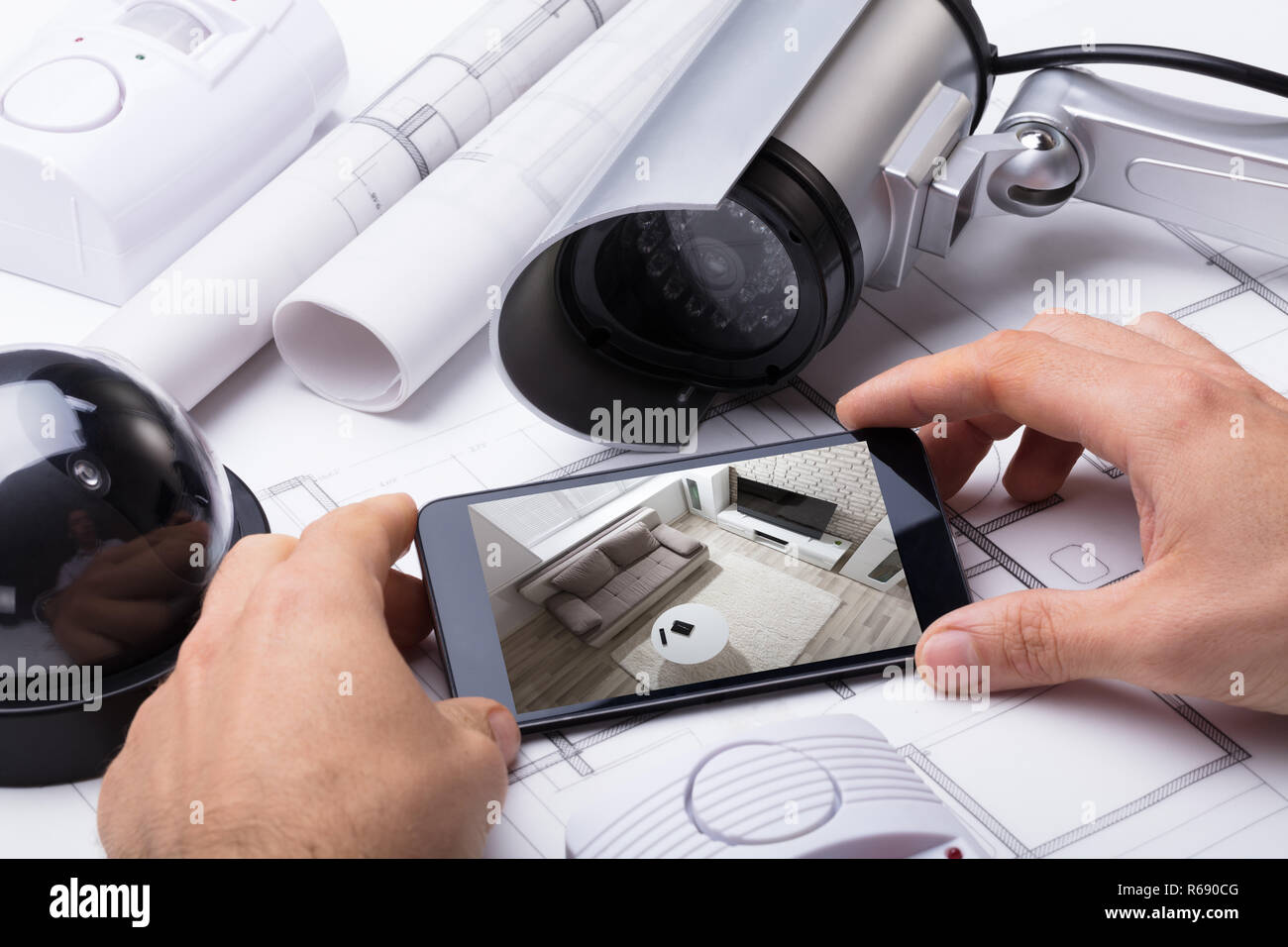 Person Hand Using Home Security System On Mobilephone Stock Photo