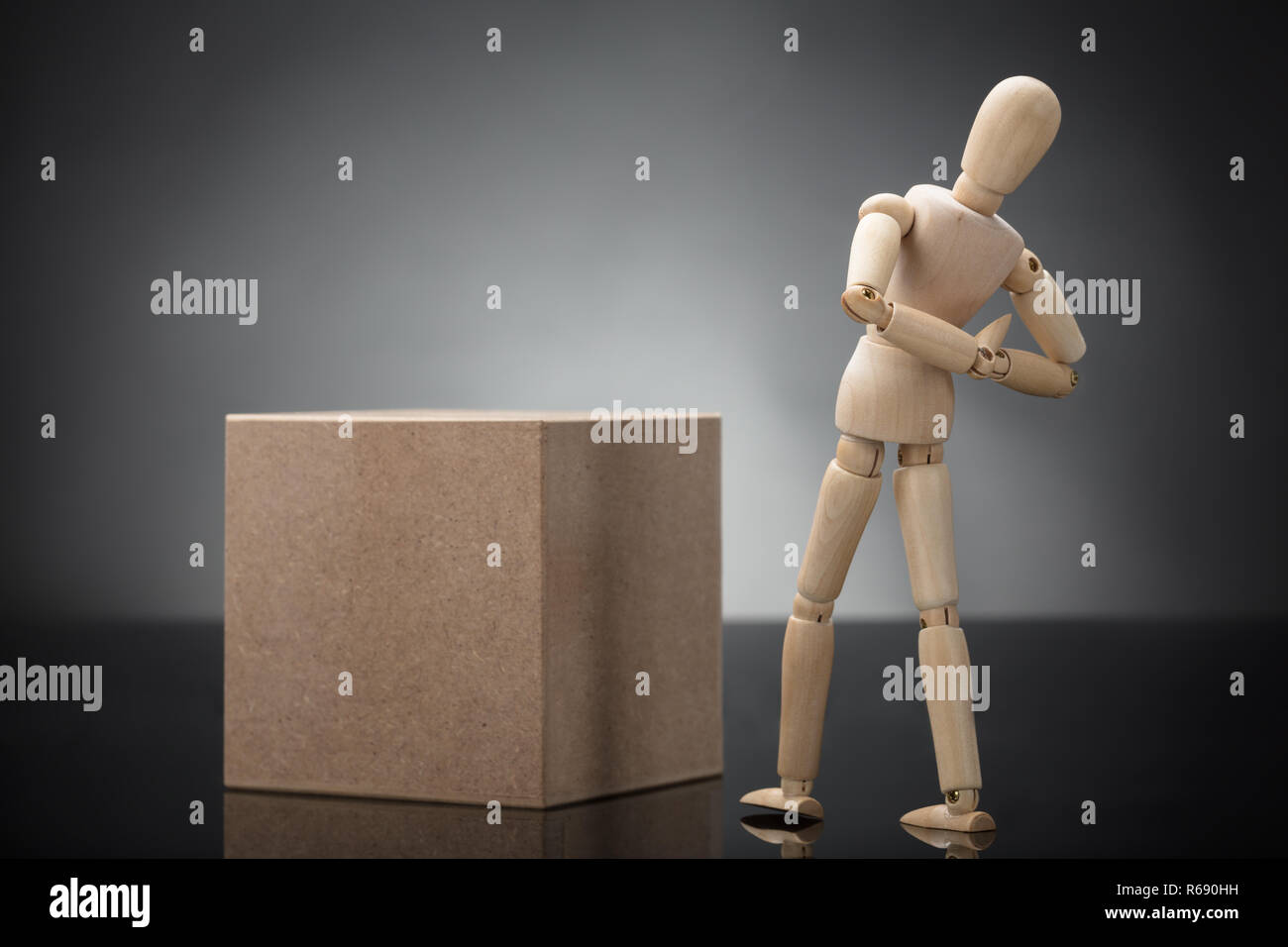 Wooden Dummy Standing Cardboard Box Suffering From Back Pain Stock Photo