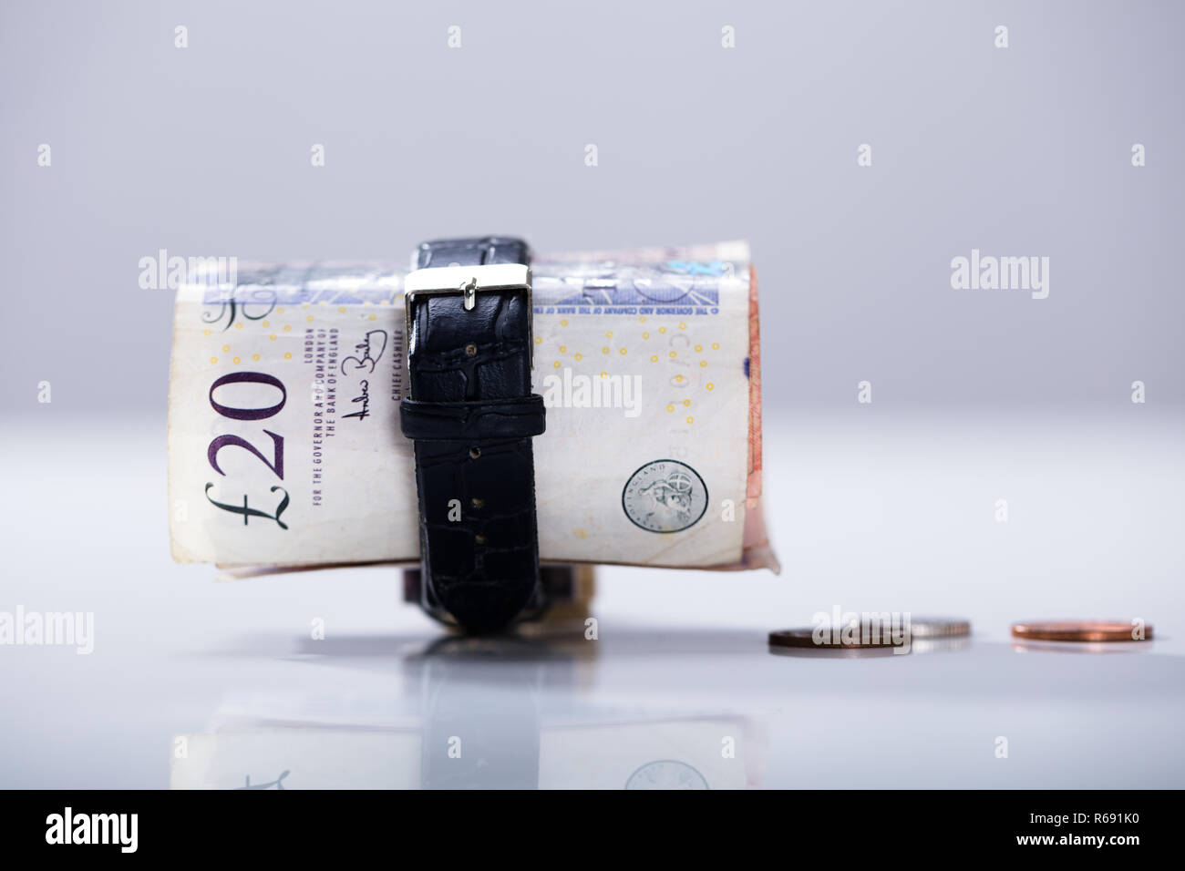 Rolled Up Twenty Pounds Currency Note Inside The Wrist Watch Stock Photo
