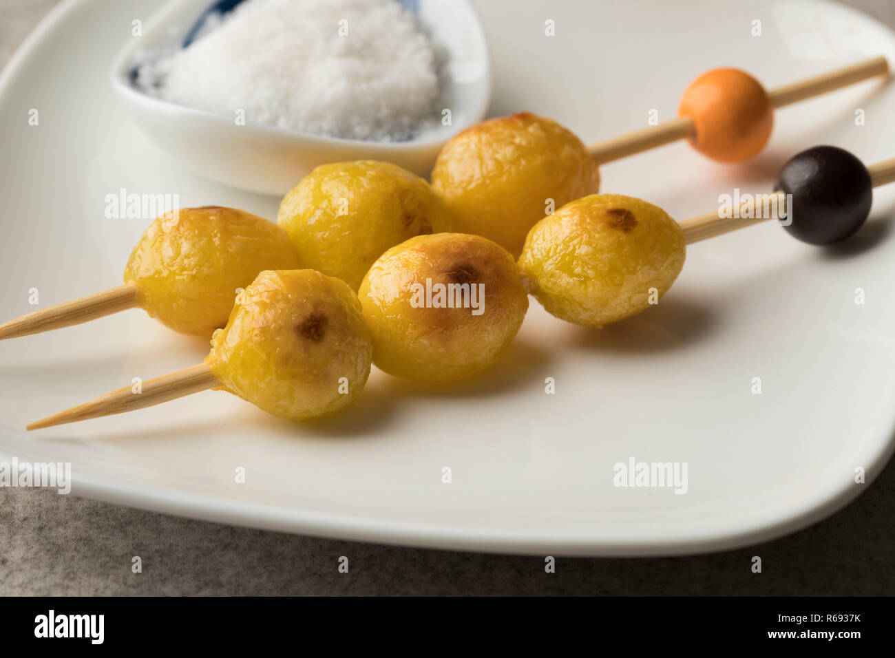 Roasted ginkgo biloba nuts close up on a stick as a snack Stock Photo