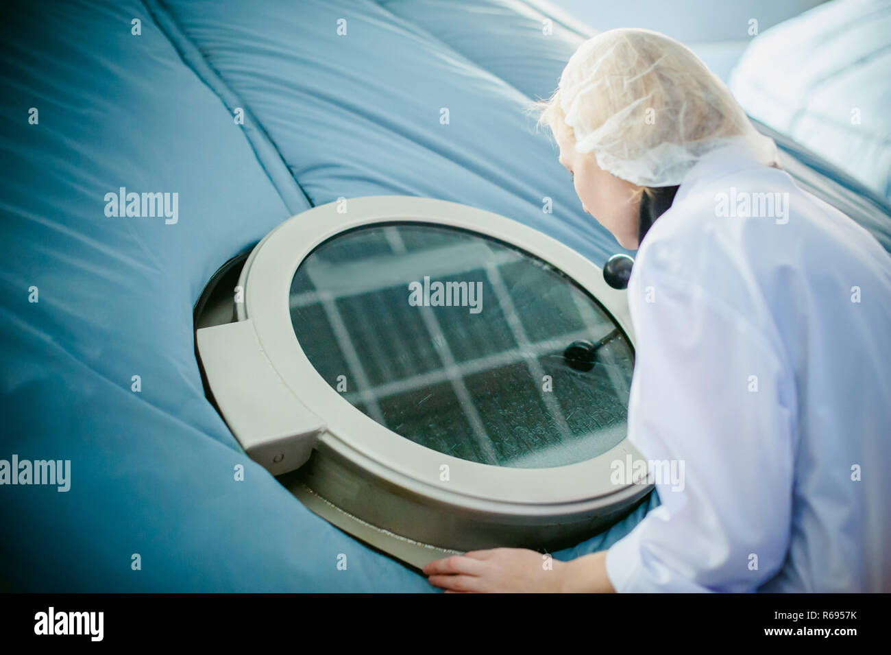 On the territory of brewer's plant with steel fermentation vats. female