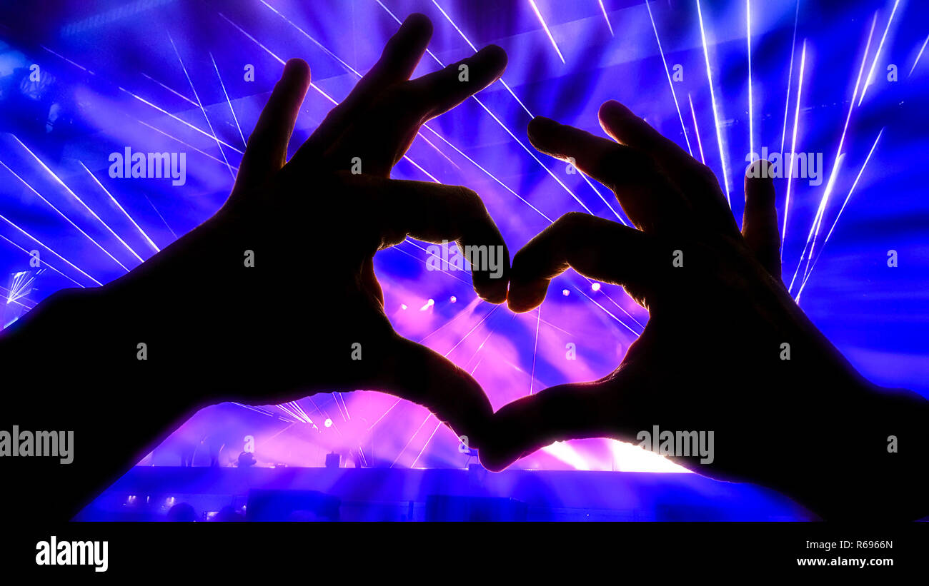 Silhouette hands in heart shape during a concert Stock Photo - Alamy