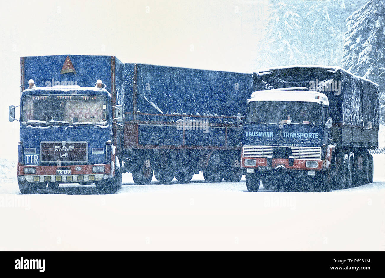 Trucks parked in a snow covered truck stopon German Autobahn in winter 1976 Stock Photo