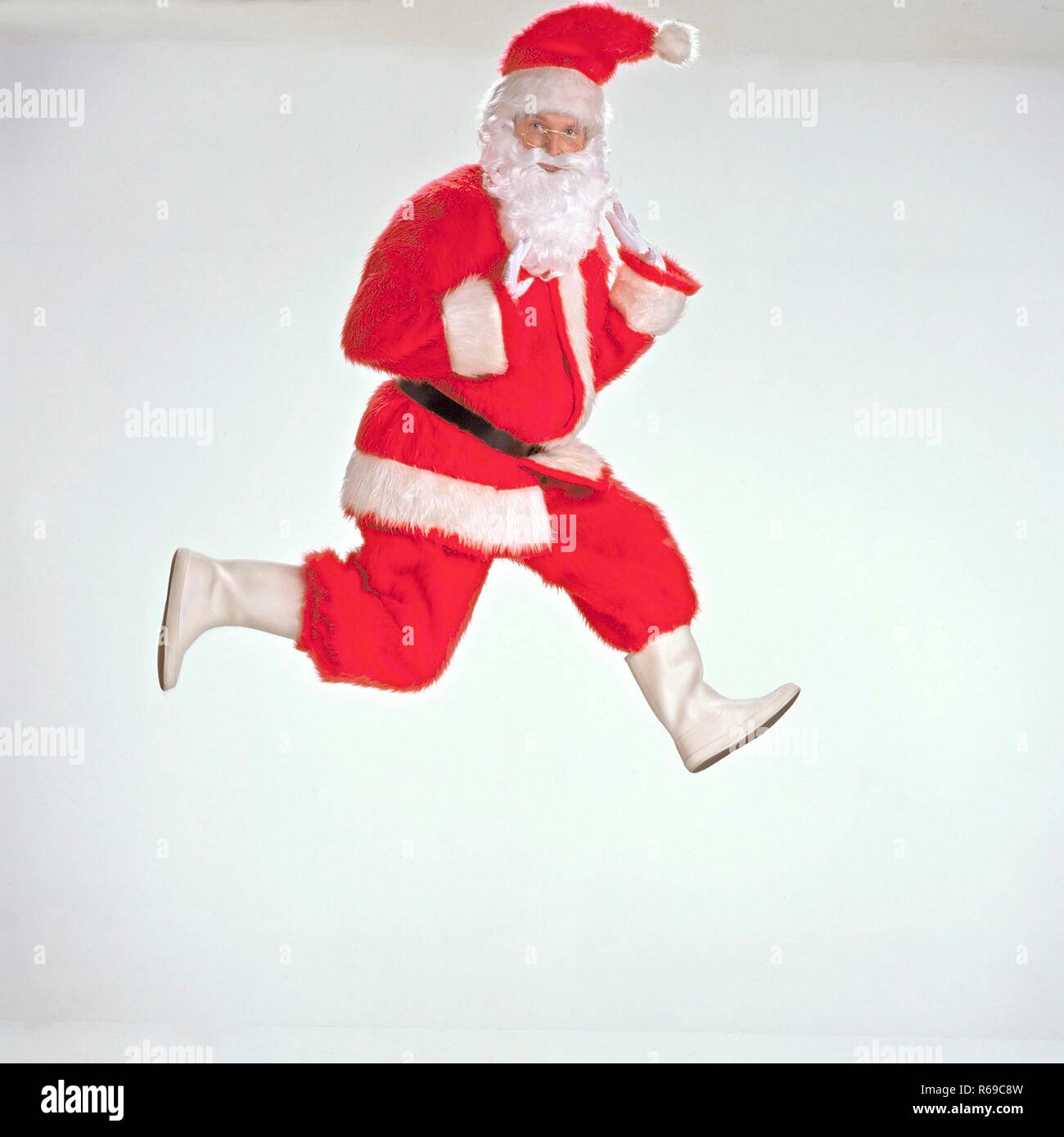 Portrait, Nikolaus, Weihnachtsmann in Rot-Weiss macht einen Luftsprung Stock Photo