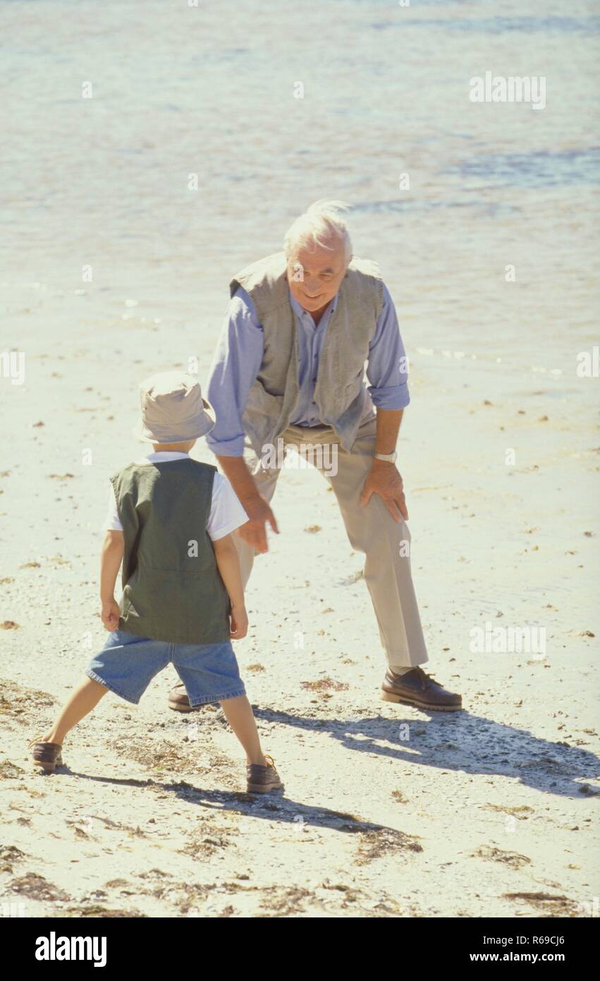 Portrait, Szene, Grossvater macht mit seinem Enkel am Strand Gymnastik Stock Photo