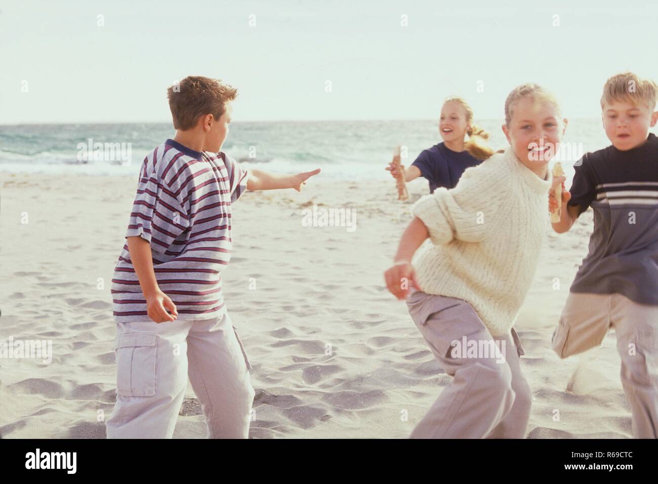 Strandszene Portrait 2 Maedchen Und 2 Jungen Im Alter Von 10 12 Jahren Bei Der Uebergabe Des Stabes Bei Einem Staffellauf Im Sand Stock Photo Alamy