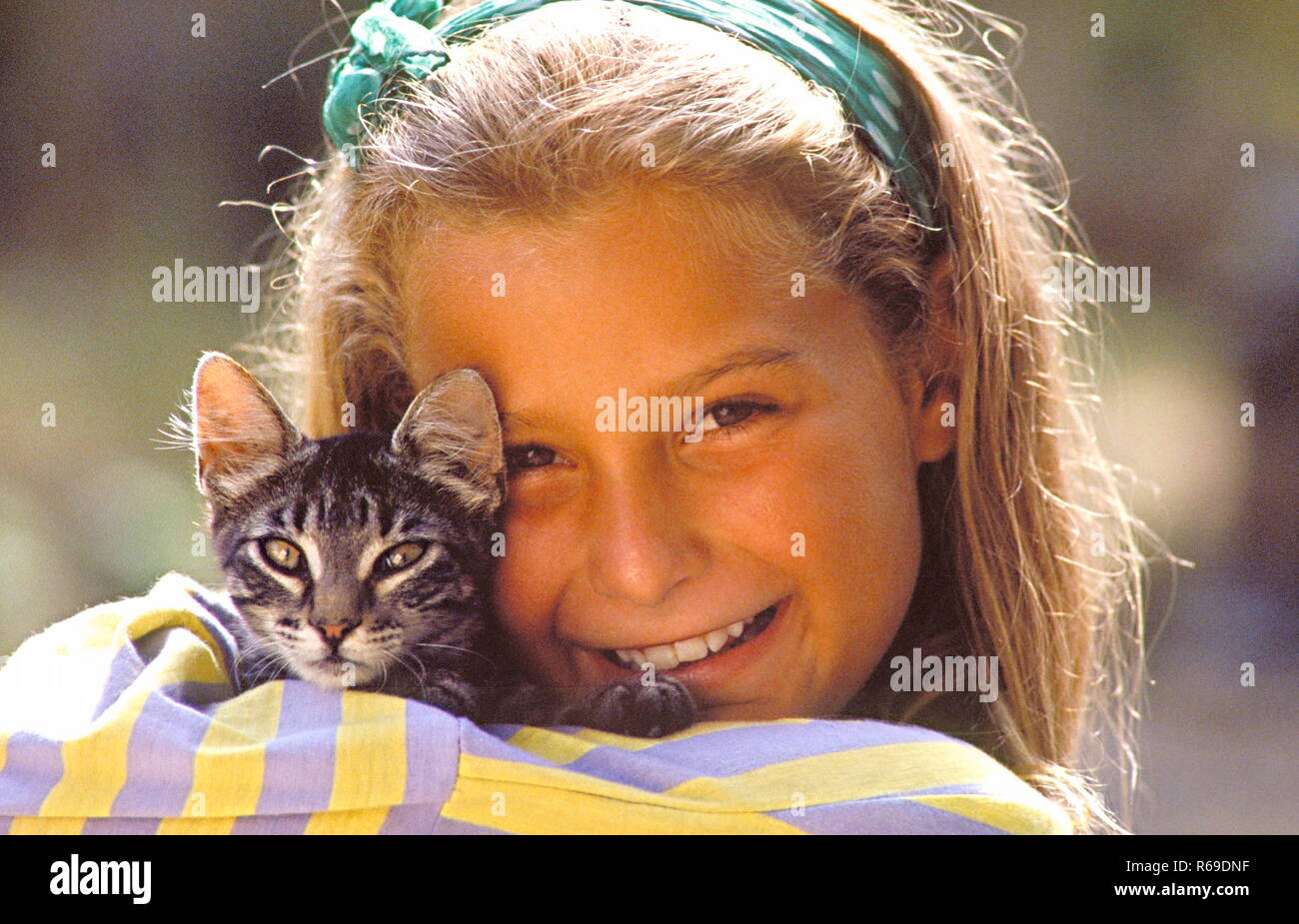 Portrait, laechelndes Maedchen mit kleiner Katze auf dem Arm Stock Photo