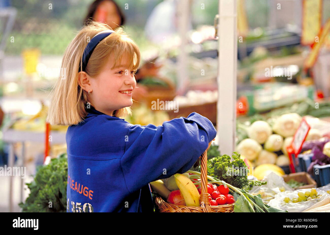 Portrait, Outdoor, blondes Maedchen kauft auf dem Markt Gemuese und Obst ein Stock Photo