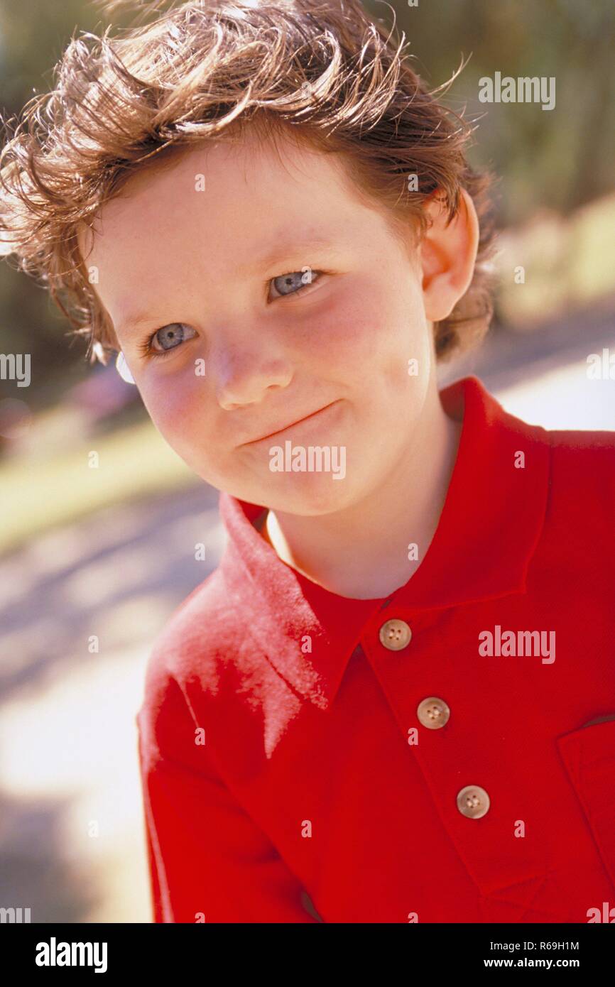 Outdoor Portrait Lustiger 8 Jaehriger Junge Mit Kurzen Strubbeligen Braunen Haaren Und Blauen Augen Bekleidet Mit Rotem Polohemd Mit Schelmisch Zusammen Gekniffenen Lippen Stock Photo Alamy