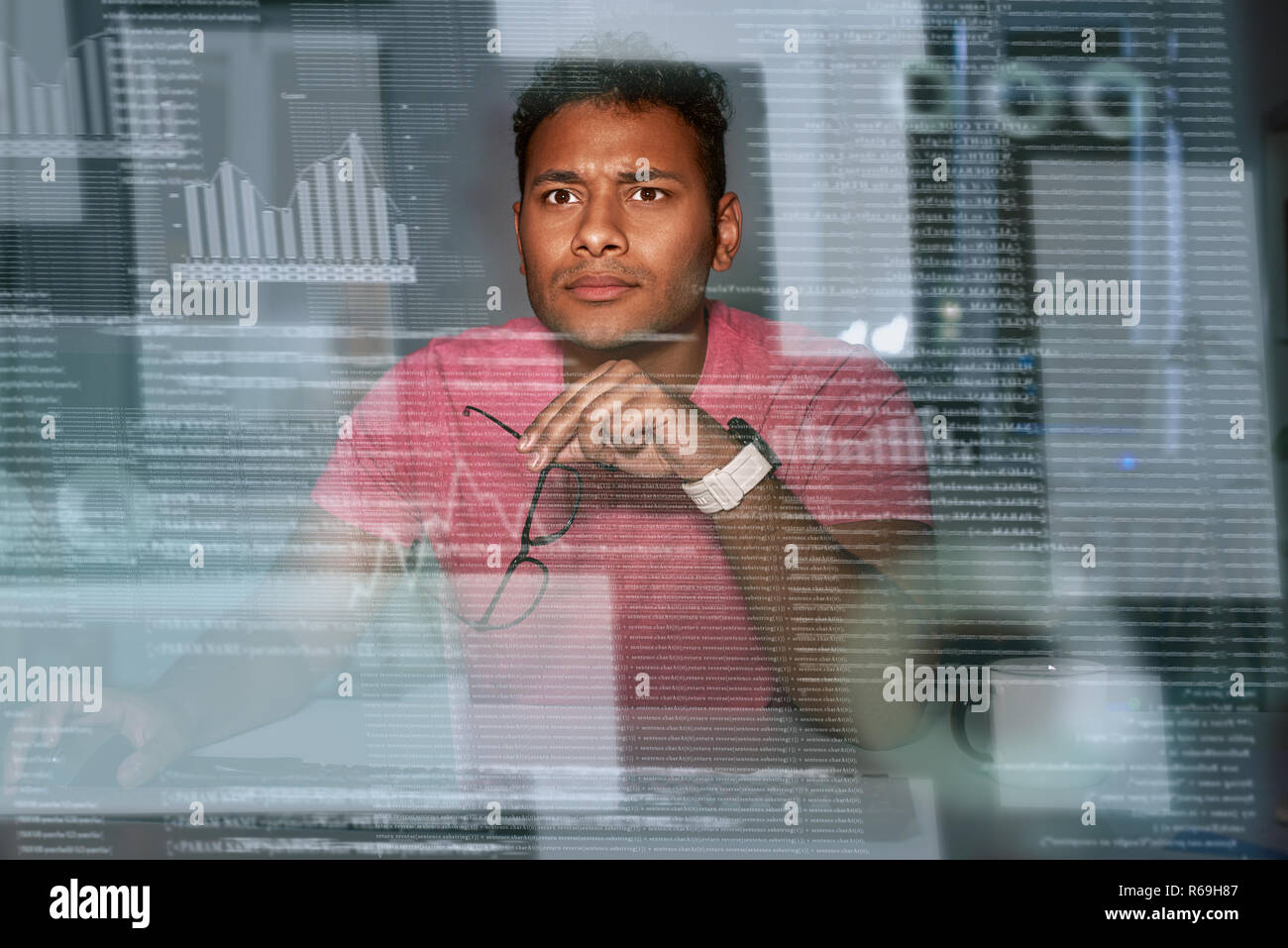 Young spectacled concentrated indian data analyst using big data Stock Photo
