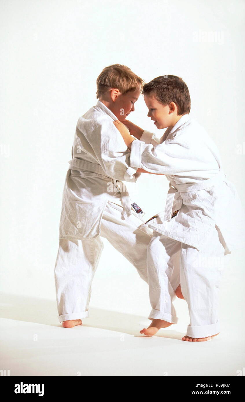 Portrait, Ganzfigur, 2 Judoka, ein blonder und ein asiatischer Junge mit kurzen Haaren, 8 Jahre, bekleidet mit Judoanzuegen beim Kampf Stock Photo