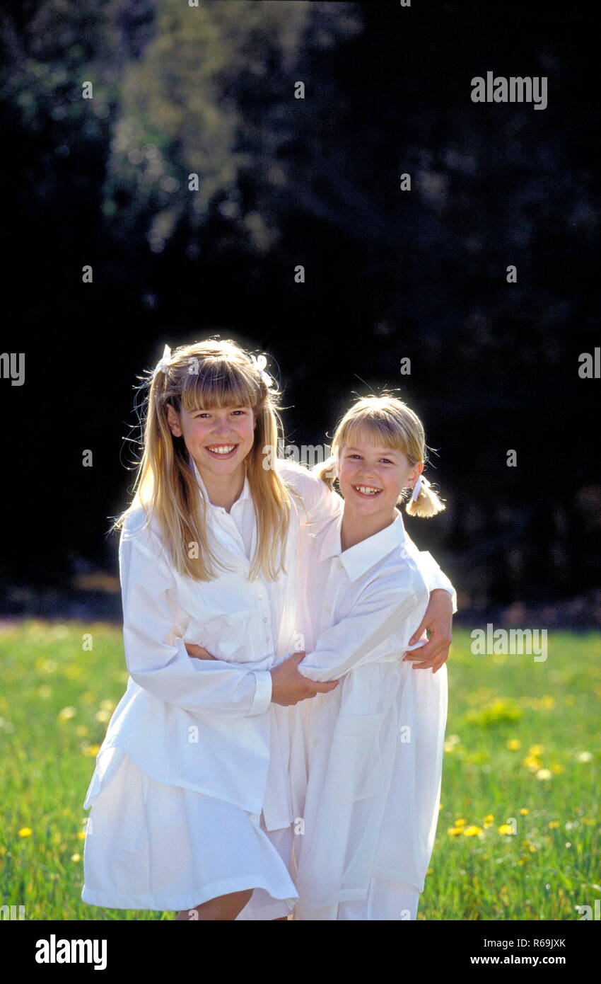 Parkszene 2 Lachende Maedchen Mit Blonden Zoepfen 8 Und 10 Jahre Bekleidet Mit Weissen Kleidern Spielen Auf Einer Parkwiese Im Sommer Stock Photo Alamy