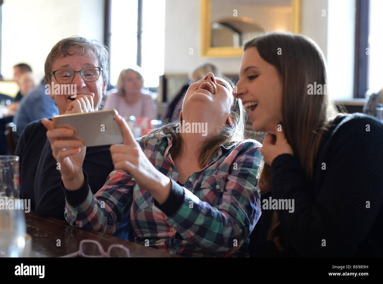 Young Women and Older Women View Smartphone, Laugh, Portrait, Café, Stuttgart, Baden-Württemberg, Germany Stock Photo