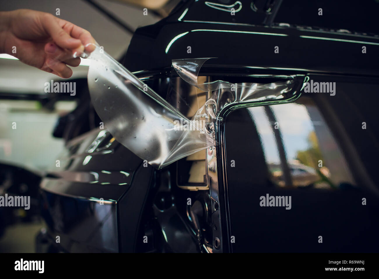 Worker hands installs car paint protection film wrap Stock Photo Alamy