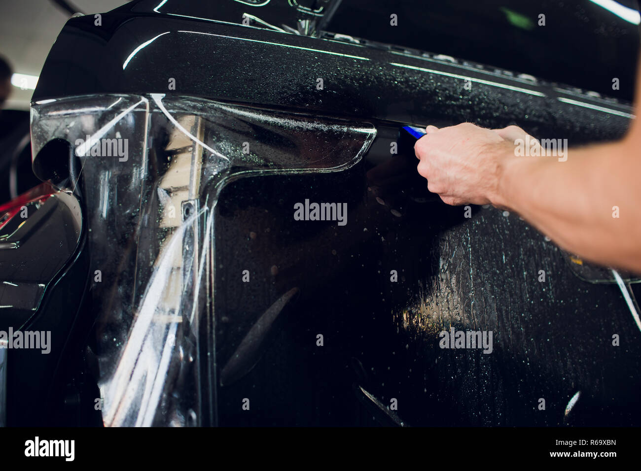 Worker hands installs car paint protection film wrap Stock Photo Alamy