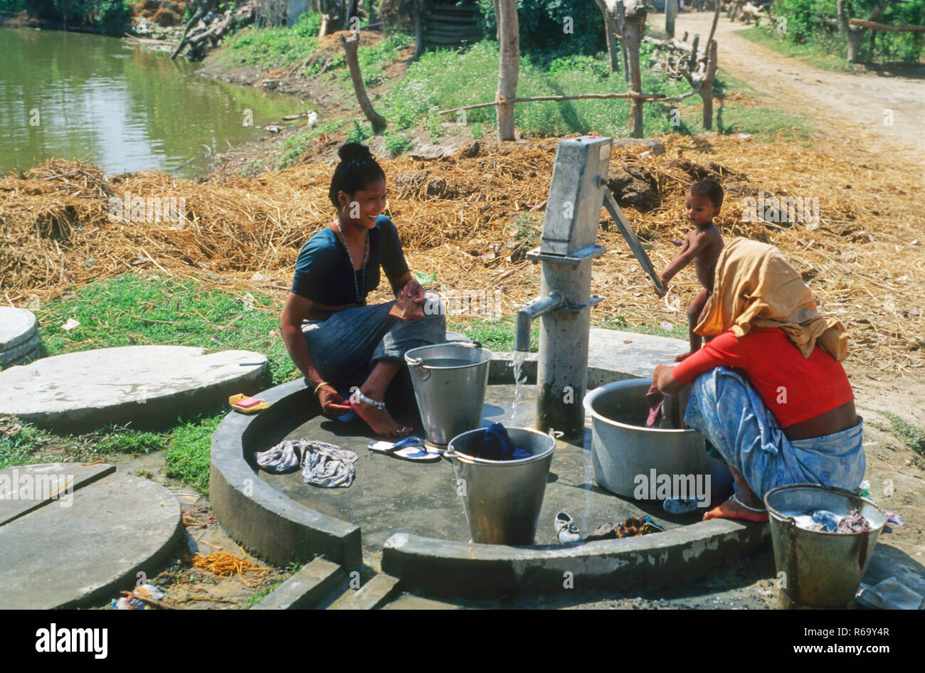 women washing clothes with village hand pump, India, Asia Stock Photo