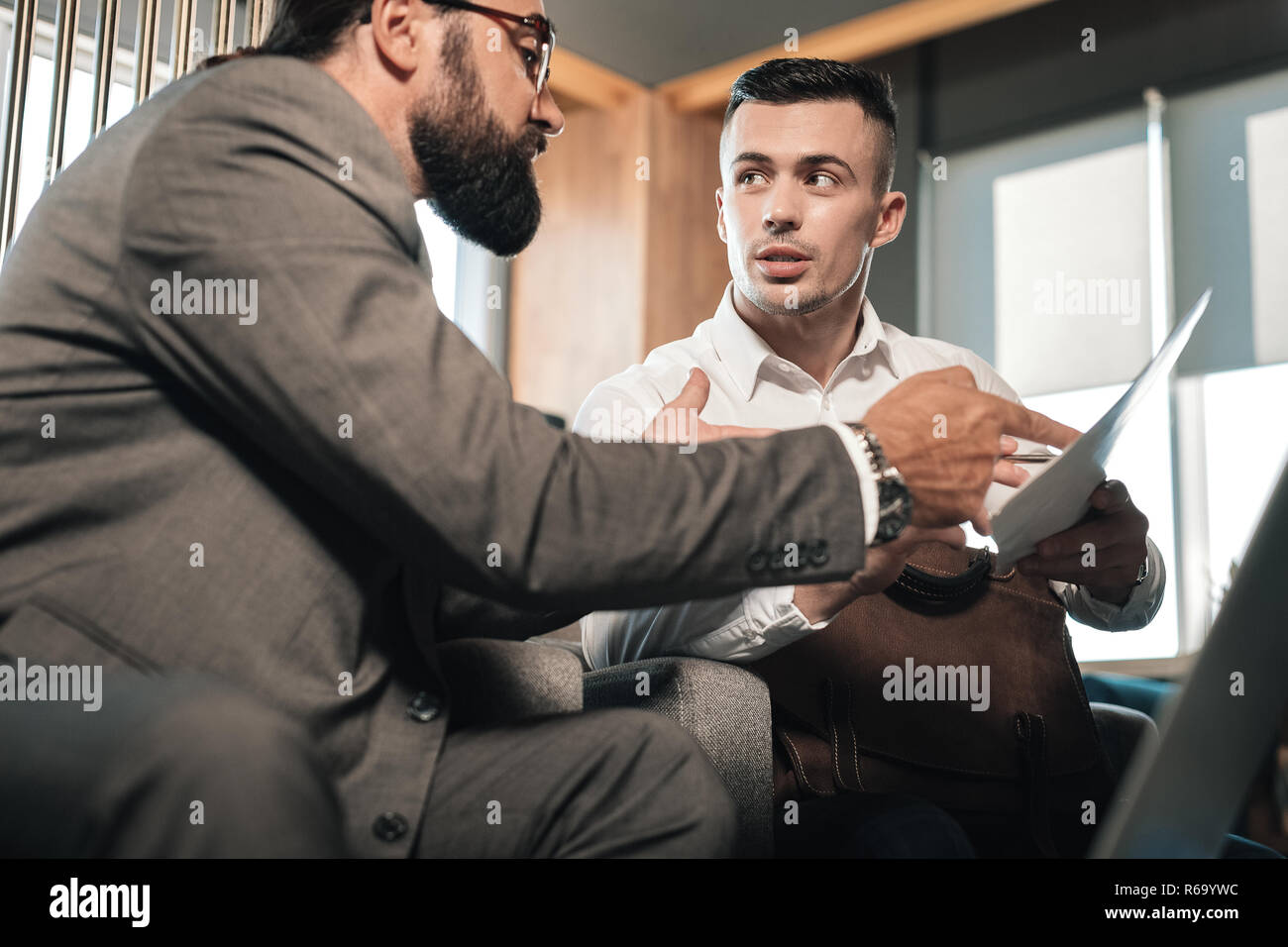 Young handsome economist speaking with employer before the meeting Stock Photo