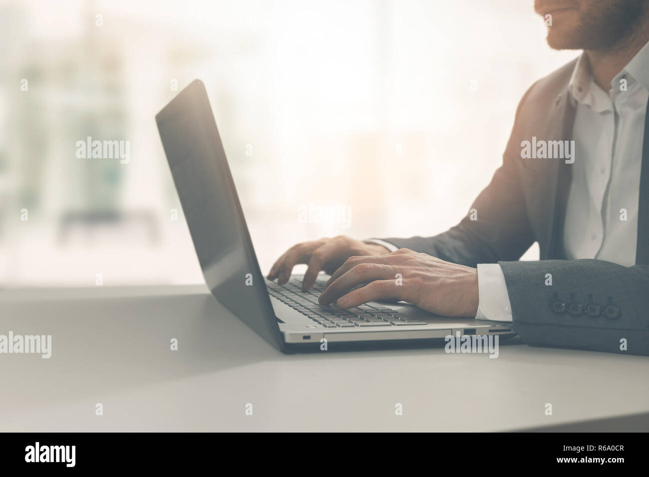 young man typing on laptop in modern bright coworking office Stock Photo