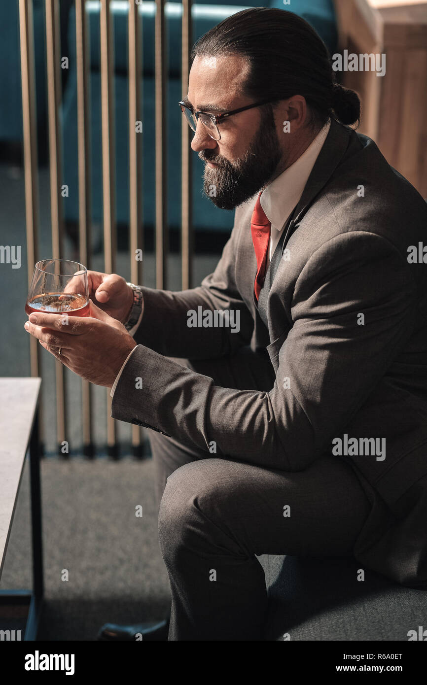 Bearded businessman having serious problems drinking alcohol Stock Photo