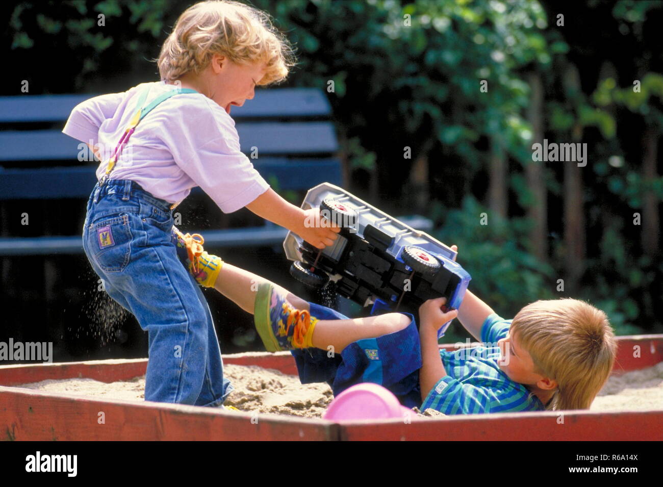 Portrait, Parkszene, 2 Jungen, 5 Jahre, streiten sich im Sandkasten um einen grossen Spielzeuglaster Stock Photo