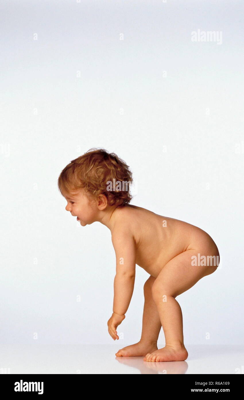 Portrait, die ersten Gehversuche eines nackten Babies, ca. 1 Jahr, gerade dabei den Oberkoerper aufzurichten Stock Photo