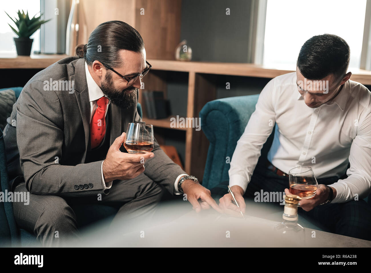 Bearded businessman persuading his business partner signing contract Stock Photo