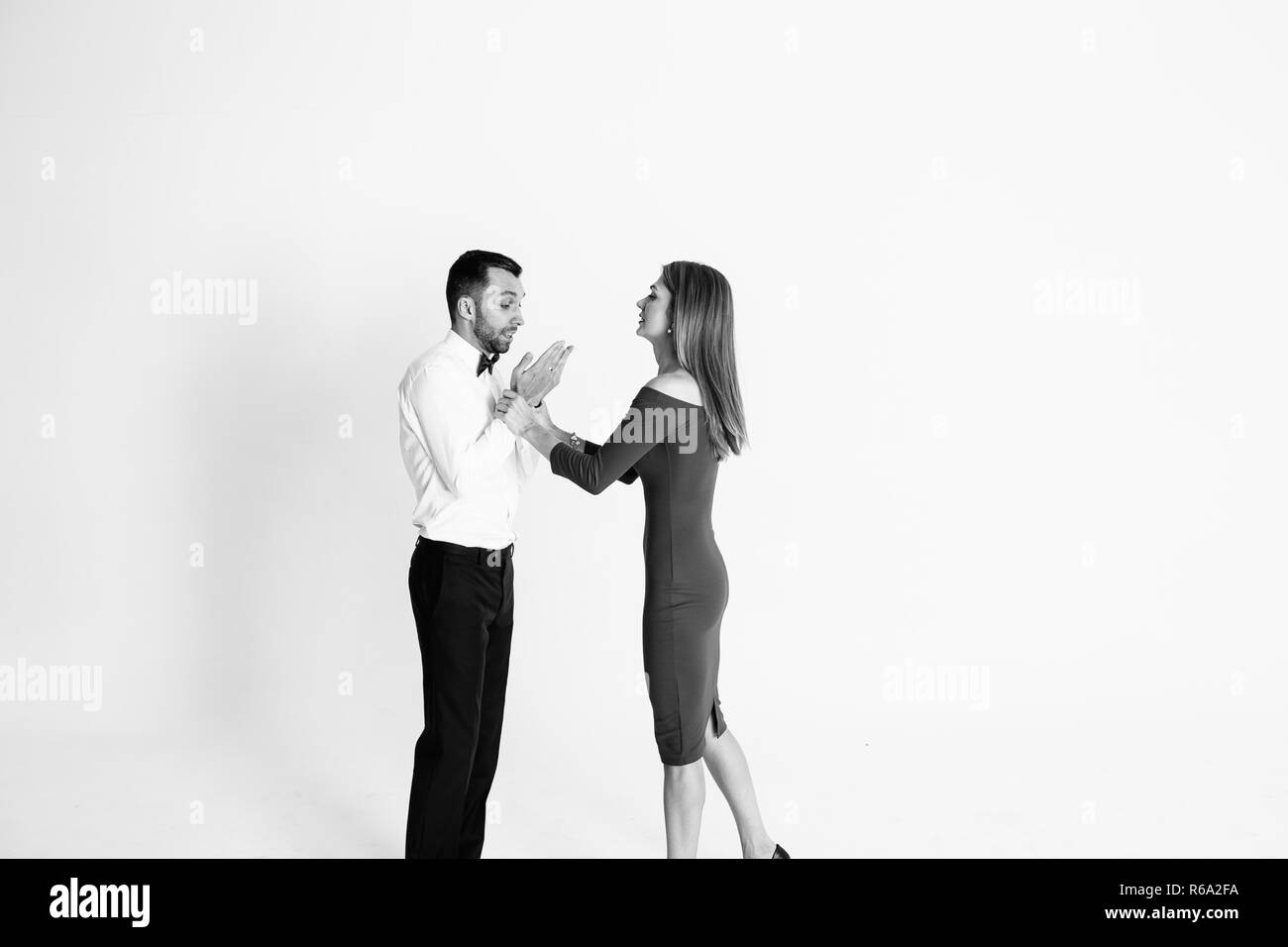 Close up studio portrait of stylish young couple, pretty woman arguing with  man, wearing white shirt and black bow tie, against plain studio backgroun  Stock Photo - Alamy