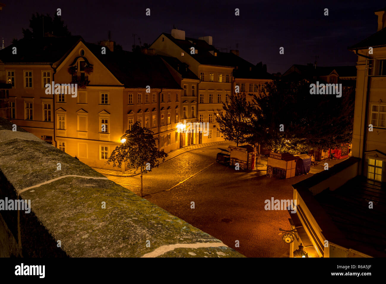 Long exposure night photo with beautiful buildings, small square and street lamps from Charles Bridge, Prague Stock Photo