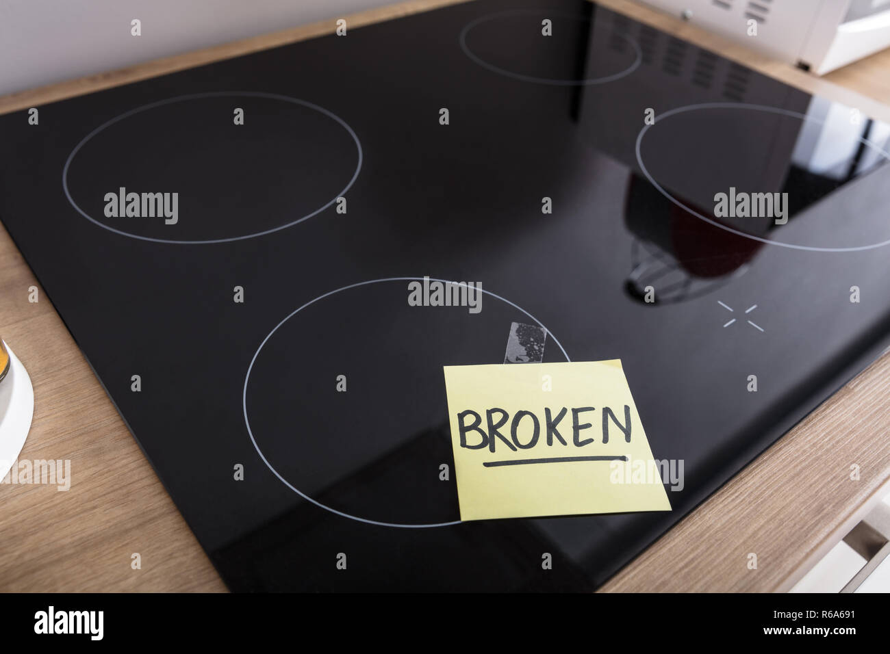 Induction Stove With Adhesive Notes Showing Broken Text Stock Photo Alamy