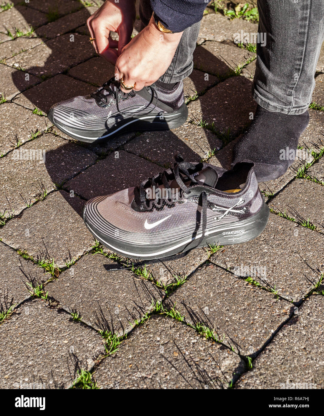 gennemsnit Droop ulv A woman tying up her laces on a pair of grey Nike Zoom Fly Gyakusou  trainers Stock Photo - Alamy