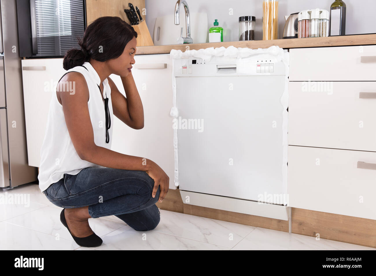 Woman Looking At Foam Coming Out From Dishwasher Stock Photo Alamy