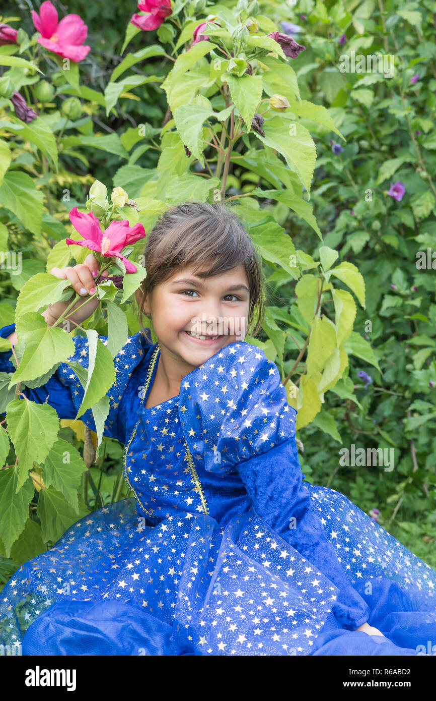 Portrait of smiling cute little girl at blooming hibiscus Stock Photo ...