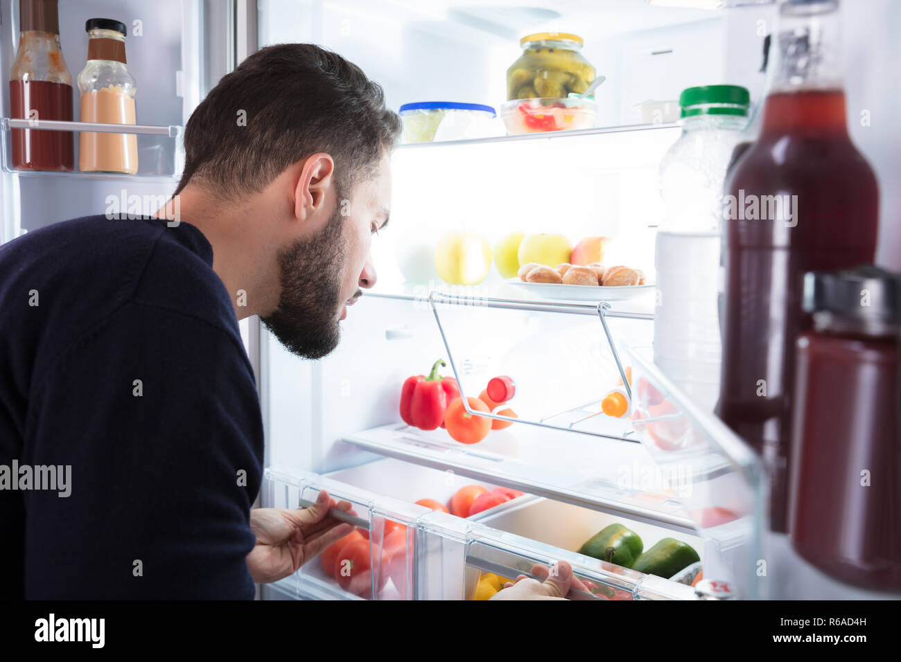 Man Looking At Vegetables In Refrigerator Stock Photo