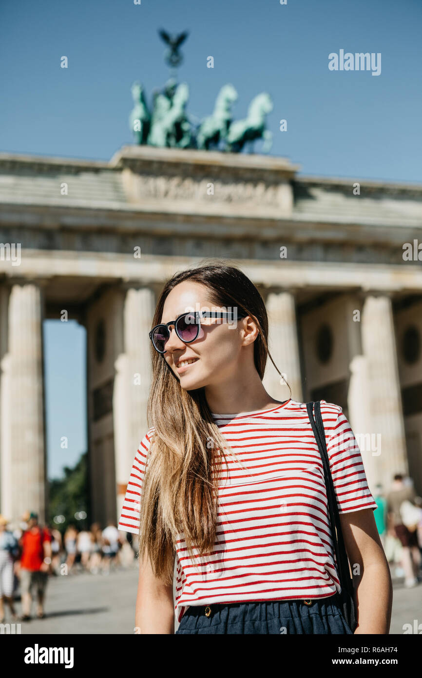 Portrait of a young beautiful positive smiling stylish tourist girl in ...